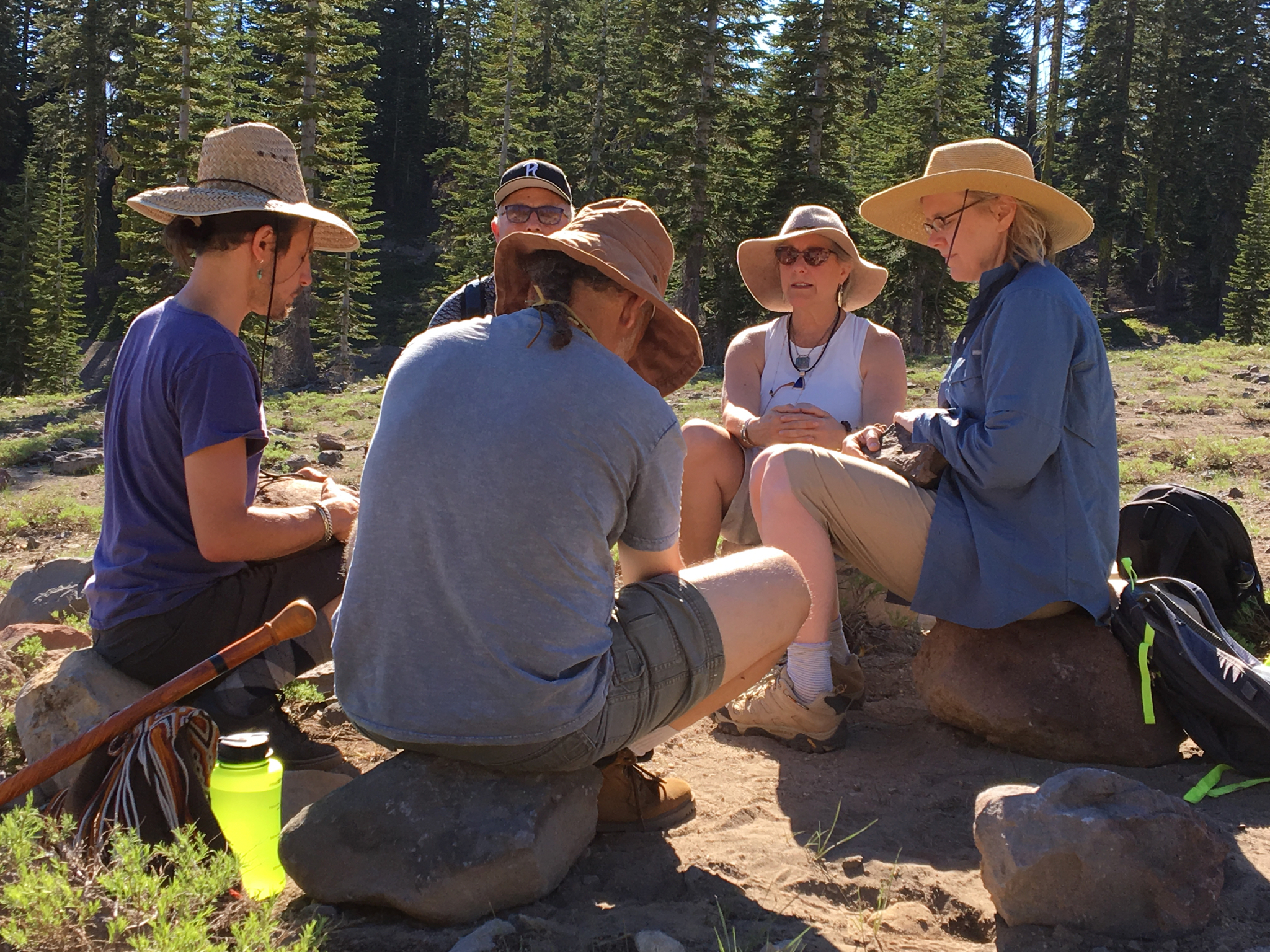 Illana in a seated circle with participants among the pines