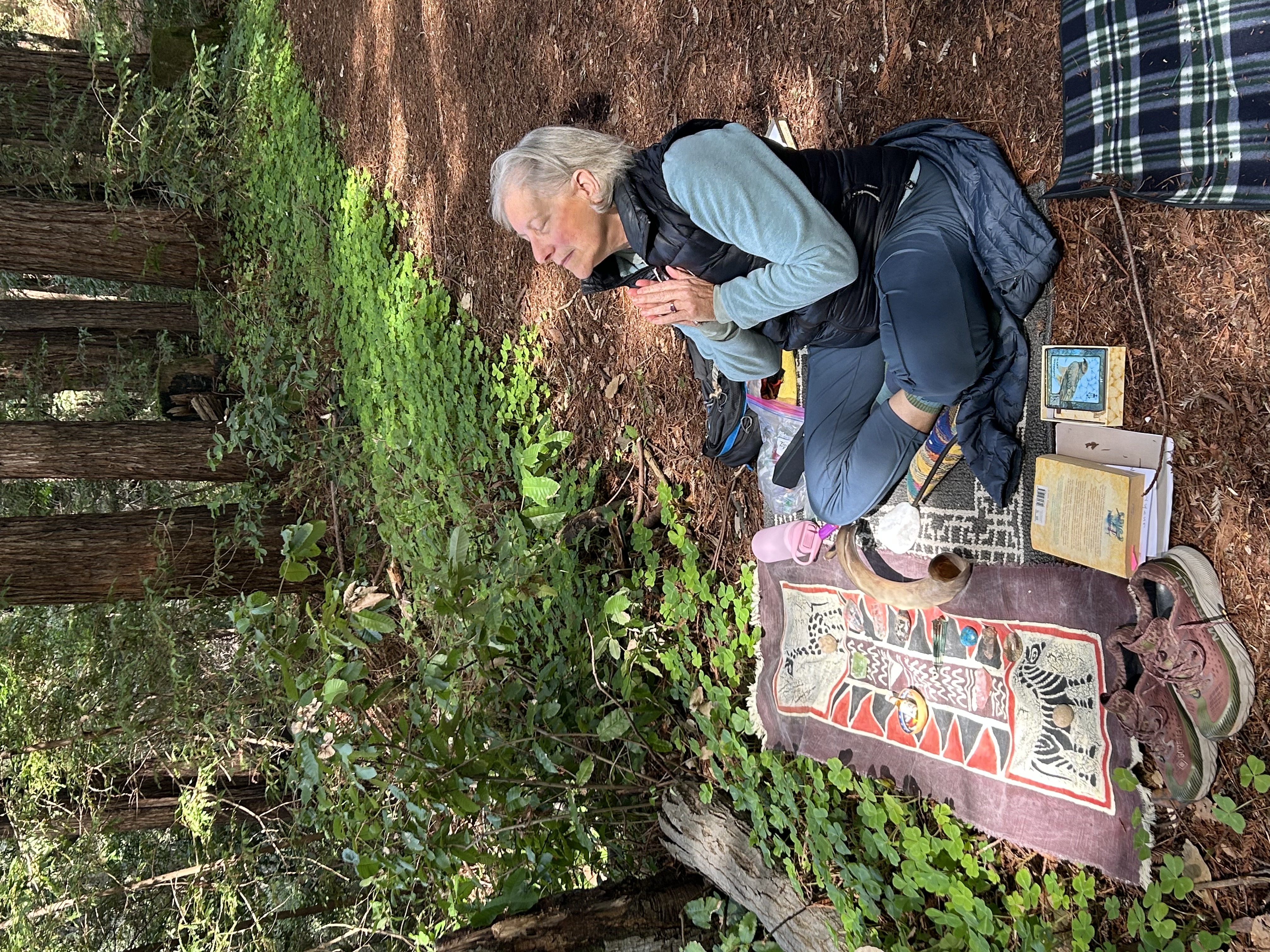 Illana in a redwood grove with her altar cloth laid out