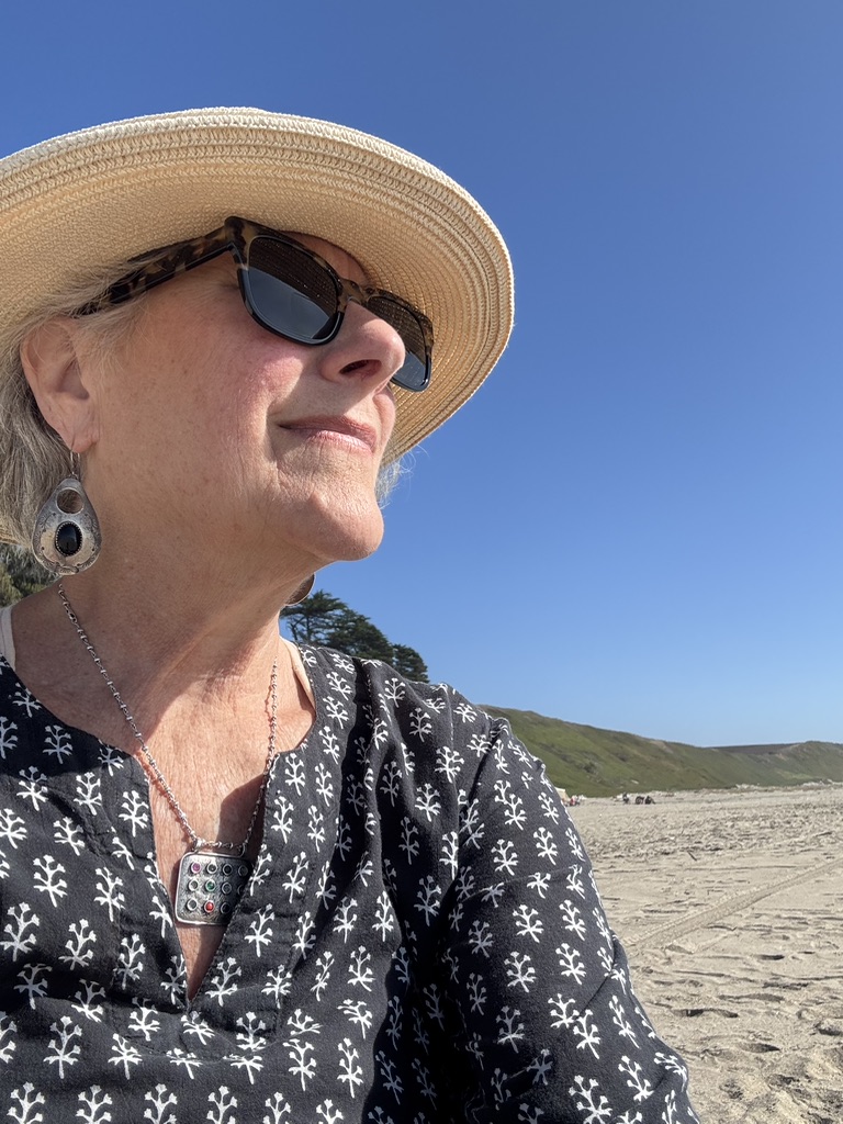 Illana in a sun hat and sunglasses, looking to the side
