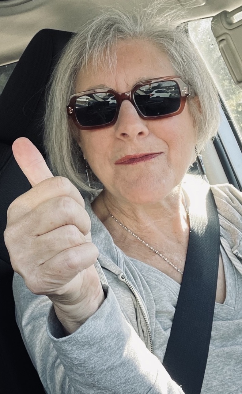 Illana smiling and giving a thumbs up